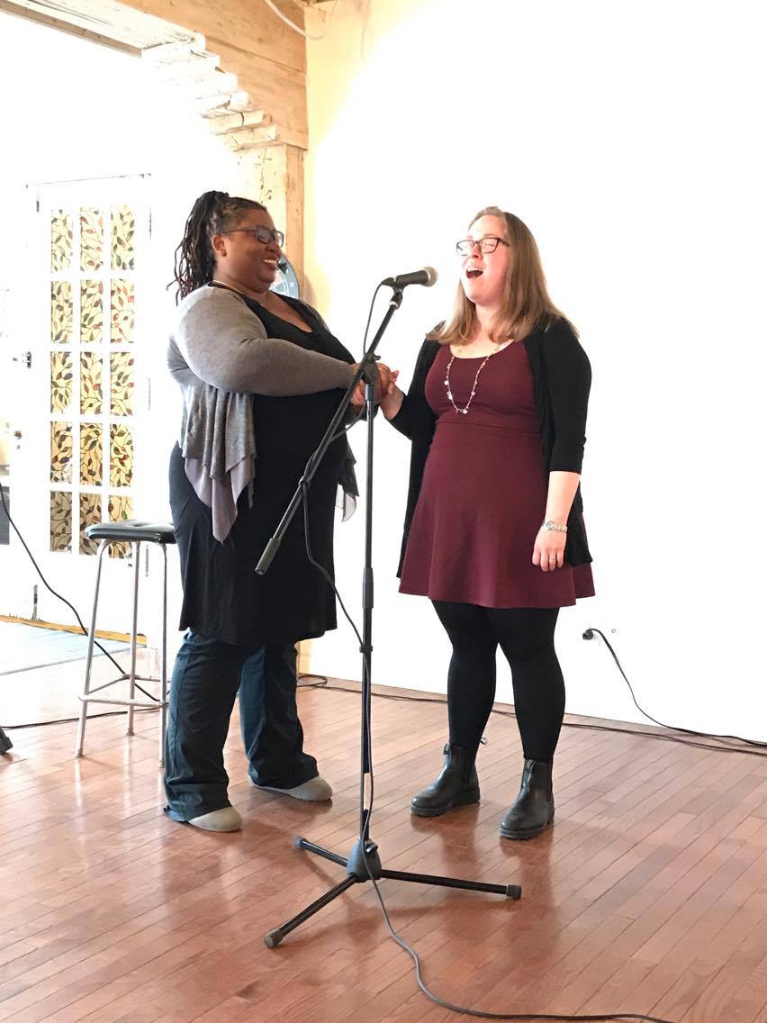 Carolyn Thompson coaching a client at the microphone